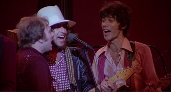 Movie still from “The Last Waltz” (1978), directed by Martin Scorsese – A group of men singing and playing instruments; Medium shot, Low angle