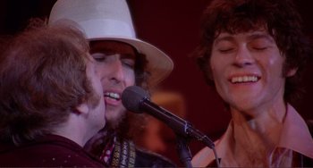 Movie still from “The Last Waltz” (1978), directed by Martin Scorsese – A group of people singing into microphones in front of a microphone; Close Up shot, Low angle