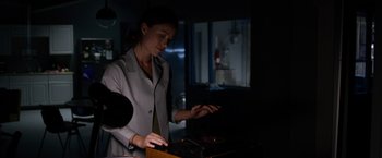 Movie still from “The Lazarus Effect” (2015), directed by David Gelb – A woman standing in front of a record player in a dark room; Medium shot, Low angle