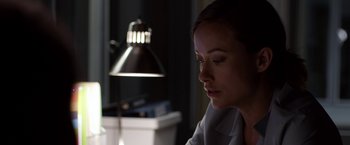 Movie still from “The Lazarus Effect” (2015), directed by David Gelb – A woman sitting in front of a lamp in a room; Close Up shot, Over the shoulder angle
