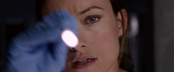 Movie still from “The Lazarus Effect” (2015), directed by David Gelb – A woman's face with a light shining on it; Extreme Close Up shot, Over the shoulder angle