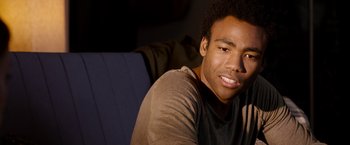 Movie still from “The Lazarus Effect” (2015), directed by David Gelb – A man sitting on a couch smiling for the camera; Close Up shot, Over the shoulder angle
