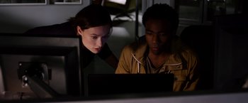 Movie still from “The Lazarus Effect” (2015), directed by David Gelb – A woman and a man looking at a computer screen; Medium shot, Over the shoulder angle