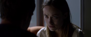 Movie still from “The Lazarus Effect” (2015), directed by David Gelb – A young woman stares at the camera while sitting in front of a man; Close Up shot, Over the shoulder angle