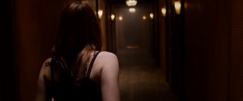 Movie still from “The Lazarus Effect” (2015), directed by David Gelb – A woman standing in a dark hallway looking at the lights; Medium shot, Over the shoulder angle