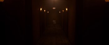 Movie still from “The Lazarus Effect” (2015), directed by David Gelb – A person standing in a dark hallway with lights on; Extreme Wide shot, High angle