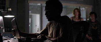 Movie still from “The Lazarus Effect” (2015), directed by David Gelb – A man sitting in front of a laptop computer; Medium shot, Over the shoulder angle