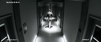 Movie still from “The Lazarus Effect” (2015), directed by David Gelb – A man walking down a hall way in a building; Wide shot, Low angle