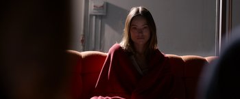 Movie still from “The Lazarus Effect” (2015), directed by David Gelb – A woman wrapped in a blanket sitting on top of a couch; Medium shot, Over the shoulder angle