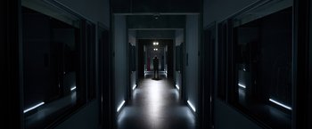 Movie still from “The Lazarus Effect” (2015), directed by David Gelb – A person standing in a dark hallway with lights on; Extreme Wide shot, High angle