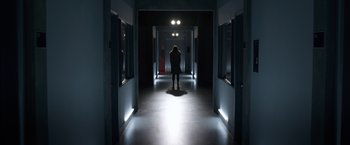 Movie still from “The Lazarus Effect” (2015), directed by David Gelb – A person is standing in a dark hallway; Wide shot, Low angle