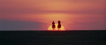 Movie still from “The Learning Tree” (1969), directed by Gordon Parks – Two people on horseback riding in the sunset; Extreme Wide shot, Low angle