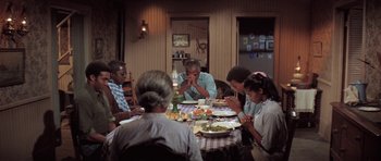 Movie still from “The Learning Tree” (1969), directed by Gordon Parks – A group of people sitting around a table eating food; Wide shot, High angle