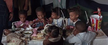 Movie still from “The Learning Tree” (1969), directed by Gordon Parks – A group of children sitting at a table eating food; Medium shot, High angle