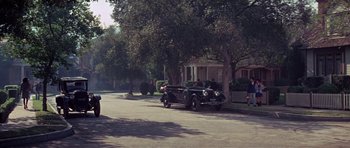 Movie still from “The Learning Tree” (1969), directed by Gordon Parks – An old car parked on the side of the street; Extreme Wide shot, High angle