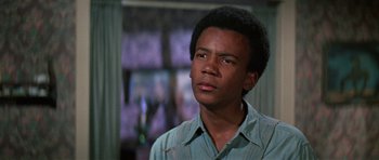 Movie still from “The Learning Tree” (1969), directed by Gordon Parks – A young man in a blue shirt looks to his left; Close Up shot, Low angle