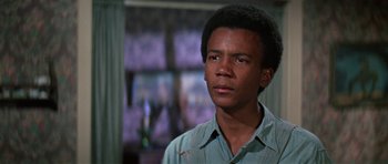 Movie still from “The Learning Tree” (1969), directed by Gordon Parks – A young man in a blue shirt is looking at the camera; Close Up shot, Low angle