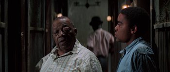 Movie still from “The Learning Tree” (1969), directed by Gordon Parks – Two men standing next to each other in front of a mirror; Close Up shot, Over the shoulder angle