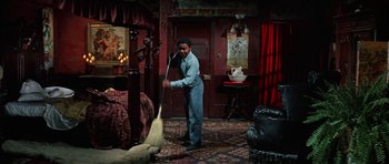 Movie still from “The Learning Tree” (1969), directed by Gordon Parks – A man sweeping the floor of a bedroom; Wide shot, High angle
