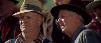 Movie still from “The Learning Tree” (1969), directed by Gordon Parks – Two older men wearing hats looking at each other; Close Up shot, Low angle