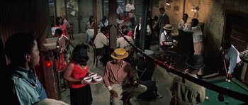 Movie still from “The Learning Tree” (1969), directed by Gordon Parks – A group of people sitting around a room; Wide shot, High angle