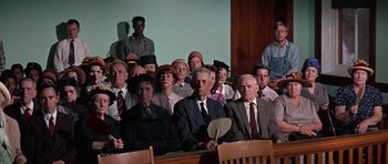 Movie still from “The Learning Tree” (1969), directed by Gordon Parks – A group of people sitting in front of a judge; Wide shot, High angle