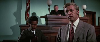 Movie still from “The Learning Tree” (1969), directed by Gordon Parks – Two men in suits and ties in front of a judge; Close Up shot, Low angle