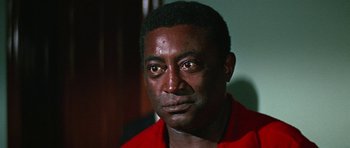 Movie still from “The Learning Tree” (1969), directed by Gordon Parks – A person wearing a red shirt; Close Up shot, Low angle