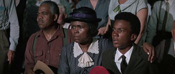 Movie still from “The Learning Tree” (1969), directed by Gordon Parks – An older woman wearing a hat and a dress; Close Up shot, High angle
