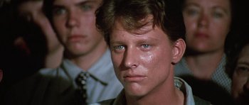 Movie still from “The Learning Tree” (1969), directed by Gordon Parks – A man with blue eyes stares into the camera; Close Up shot, Over the shoulder angle