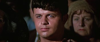 Movie still from “The Learning Tree” (1969), directed by Gordon Parks – A person wearing a shirt with blue eyes; Close Up shot, Low angle