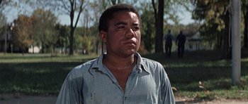 Movie still from “The Learning Tree” (1969), directed by Gordon Parks – A man in a blue shirt is looking to his left; Close Up shot, Low angle