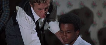 Movie still from “The Learning Tree” (1969), directed by Gordon Parks – A man and a young man in a room with flowers; Close Up shot, Over the shoulder angle