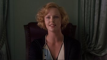 Movie still from “The Legend of Bagger Vance” (2000), directed by Robert Redford – A woman sitting in a chair with a smile on her face; Close Up shot, Low angle