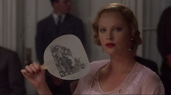 Movie still from “The Legend of Bagger Vance” (2000), directed by Robert Redford – A woman holding a hand fan in front of her face; Close Up shot, Over the shoulder angle