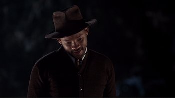 Movie still from “The Legend of Bagger Vance” (2000), directed by Robert Redford – A man wearing a hat and a brown jacket; Close Up shot, Over the shoulder angle