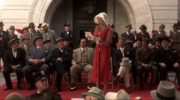 Movie still from “The Legend of Bagger Vance” (2000), directed by Robert Redford – A woman in a red dress is holding a microphone; Medium shot, Low angle