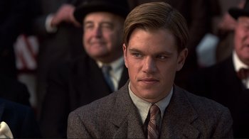 Movie still from “The Legend of Bagger Vance” (2000), directed by Robert Redford – A man in a suit and tie next to another man in a suit and tie; Close Up shot, Low angle