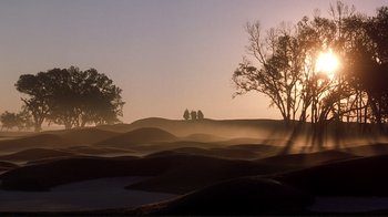 Movie still from “The Legend of Bagger Vance” (2000), directed by Robert Redford – The sun is setting over a field with trees in the background; Extreme Wide shot, Low angle