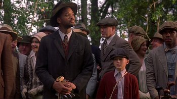 Movie still from “The Legend of Bagger Vance” (2000), directed by Robert Redford – A group of people in suits and hats; Medium shot, Low angle