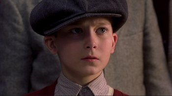 Movie still from “The Legend of Bagger Vance” (2000), directed by Robert Redford – A young boy wearing a hat and a tie; Close Up shot, High angle