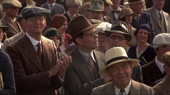 Movie still from “The Legend of Bagger Vance” (2000), directed by Robert Redford – A group of people in suits and hats clapping; Medium shot, Over the shoulder angle