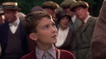 Movie still from “The Legend of Bagger Vance” (2000), directed by Robert Redford – A young boy looking up at a crowd of people; Close Up shot, Low angle