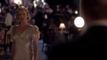 Movie still from “The Legend of Bagger Vance” (2000), directed by Robert Redford – A woman in a white dress standing next to a table; Medium shot, Over the shoulder angle