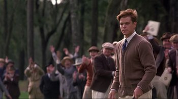 Movie still from “The Legend of Bagger Vance” (2000), directed by Robert Redford – A group of people standing in a line waving hands; Medium shot, Low angle