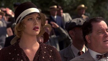 Movie still from “The Legend of Bagger Vance” (2000), directed by Robert Redford – A woman in a brown dress with a hat on her head; Close Up shot, Low angle
