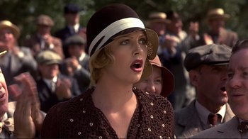 Movie still from “The Legend of Bagger Vance” (2000), directed by Robert Redford – A woman in a brown dress and a brown hat; Close Up shot, Over the shoulder angle
