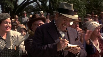 Movie still from “The Legend of Bagger Vance” (2000), directed by Robert Redford – An old man in a hat is writing on a piece of paper; Medium shot, Over the shoulder angle