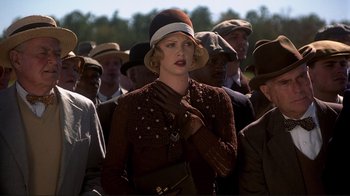 Movie still from “The Legend of Bagger Vance” (2000), directed by Robert Redford – A group of people standing in a crowd wearing hats and gloves; Medium shot, Low angle