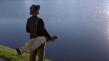 Movie still from “The Legend of Bagger Vance” (2000), directed by Robert Redford – A man standing on the shore of a body of water; Wide shot, Low angle